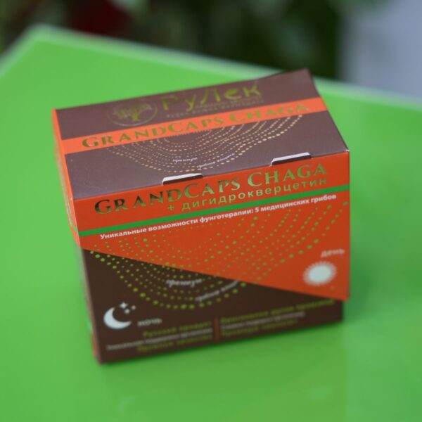 na staklenom zelenom stolu nalazi se kutija preparata GRANDCaps, danonoćna formula