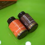 na zelenoj površini nalaze se dve bočice po 60 kapsula GRANDCaps čage sa dihidrokvercetinom, u ćošku se nazire kutija preparata