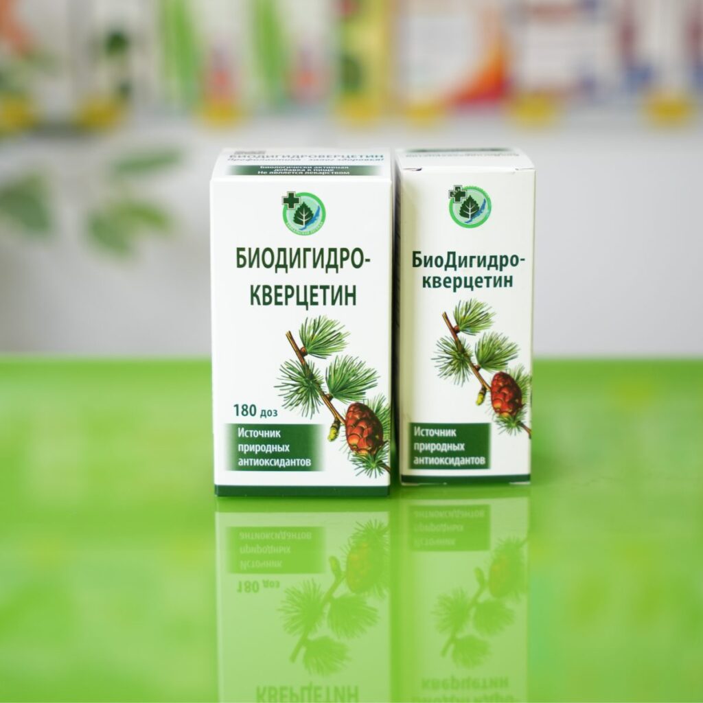 prikaz manjeg i većeg pakovanja biodihidrokvercetina (taksifolin) na zelenoj staklenoj površini