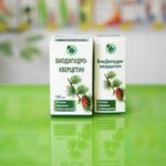 prikaz manjeg i većeg pakovanja biodihidrokvercetina (taksifolin) na zelenoj staklenoj površini